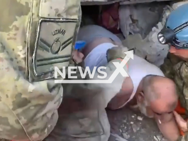 Soner Tugtekin smokes a cigarette during his rescue in Adıyaman, Turkey, in undated footage. Emergency services successfully rescued the man. Note: Picture is a screenshot from a video (@tcsavunma/Newsflash)