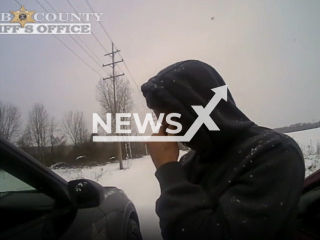 A man cries near police car in Macomb County, Michigan, USA in undated footage. The driver shared with police that he had multiple stressing issues in his life. Note: Picture is a screenshot from a video (@macombcountysheriffsoffice/Newsflash)