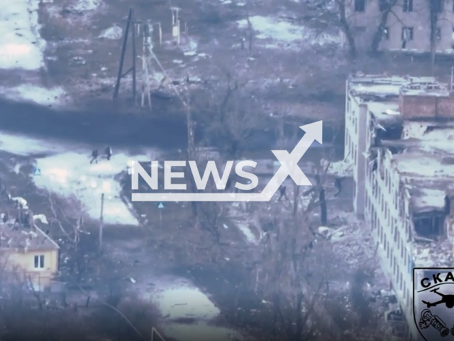 Russian soldiers move near damaged residential building in Bakhmut, Donetsk region, Ukraine in undated footage. The footage was released by the Reconnaissance Battalion "Skala" on Thursday, Feb. 9, 2023. Note: Picture is screenshot from a video. (@skala_battalion/Newsflash)