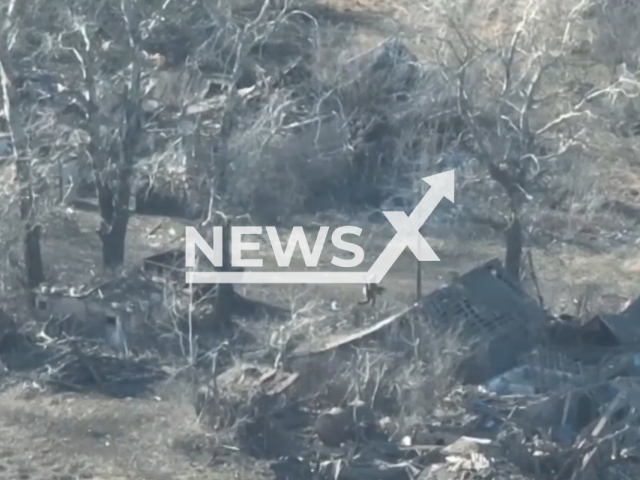 A Russian soldier runs near destroyed residential buildings in Ukraine in undated footage. The footage was released by the 10th brigade of the Ukrainian Ground Forces on Monday, Feb. 13, 2022. Note: Picture is a screenshot from a video (10 brigade/Newsflash)