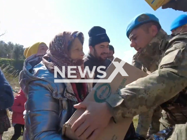 Soldier gives aid materials to an elderly woman in Turkey, in undated footage. Thousands of people have been left injured and homeless as a result of the earthquake.  Note: Picture is screenshot from a video. (@TCMilliSavunmaBakanligi/Newsflash)