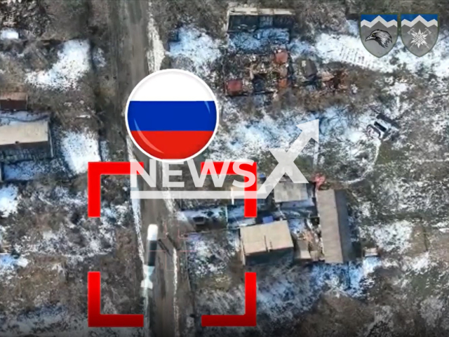 Ukrainian drone bomb falls on Russian soldiers walking down the road in a residential area in Ukraine in undated footage. The footage was released by the 109th battalion of the Ukrainian Ground Forces on Friday, Feb. 17, 2022. Note: Picture is screenshot from a video. (@109OGSHB/Newsflash)