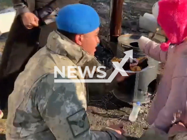 Soldier gives a plate full of sweets with a candle on top to little girl named Aysegul to celebrate her birthday in Pazarcik in the Kahramanmaras Province, Turkey, undated. Little Aysegul had lost her mother in the earthquake. Note: Picture is a screenshoot from a video (TR Ministry of National Defense/Newsflash)