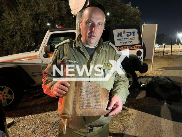 Photo shows Major Haim Otmazgin, commander of the ZAKA search-and-rescue force, holding the Book of Esther, undated. Major Haim Otmazgin reportedly took the Book of Esther from an elderly man in Antakya, Hatay, Turkey, during rescue operations. Note: Picture is private (ZAKA/Newsflash)