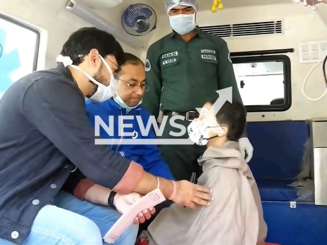 Picture shows Sujan Majhi with his 10-year-old son, after he was removed from the house, with a medic (left)  in Gurgaon, India,  on Tuesday, Feb 22, 2023. Munmun Majhi, 36,  locked herself and her 10-year-old son in their house for three years, fearing they would contract Covid-19, was brought out of confinement by a team of police, health officials who had to break open the main door.
 Note: Photo is a screenshot from a video. (Newsflash)