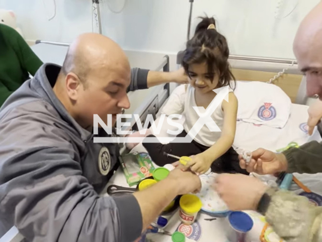 Soldiers play with an earthquake victim, Fatma, 4, in Turkey, in undated footage. Thousands of people have been left injured and homeless as a result of the earthquake. Note: Picture is a screenshot from a video. (@TCMilliSavunmaBakanligi/Newsflash)