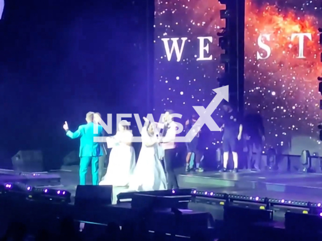 Two brides stand on stage with their favourite band in Metro Manila, Philippines, Monday, Feb. 20, 2023. Brides still wearing their white gowns ditched their wedding reception to watch the Irish pop group Westlife. Note: Picture is a screenshot from a video. (Newsflash)