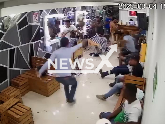 Picture shows a  hitman attempting to shoot a man in a barbershop in Cartagena, Colombia, on Saturday, March, 4, 2023. Football player Rafael Santos Mercado, 17,   was accidentally shot in the leg during  the attack. Note: Picture is screenshot from a video. (Newsflash)