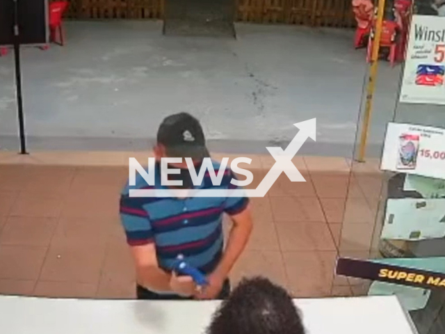 Man points a hot glue gun at a store worker to rob the store  in Saquarema, Brazil, on Friday, March, 3, 2023. The liquor  store attendant thought the robber was joking, witnesses caught him outside and he was arrested. Note: Picture is screenshot from a video. (Newsflash)