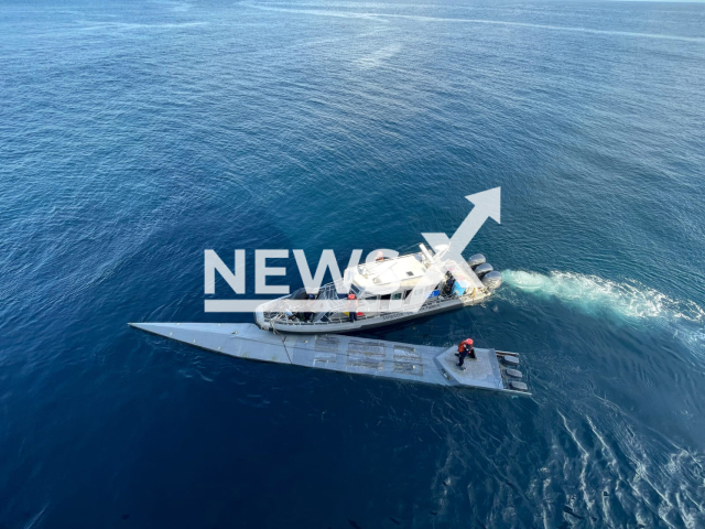 Picture shows Colombian Police boat  next to a submarine transporting 2643 kilograms of cocaine, undated.
Two bodies and two suspects in poor health from inhaling toxic gases from the fuel were found onboard in the Pacific, by Colombian Police.
Note: Licensed photo.  (Colombian Navy/Newsflash)