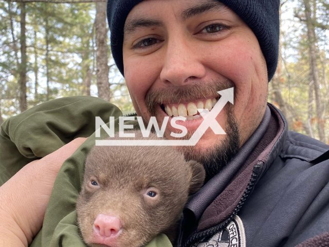 Conservation officers  hug a bear cub during a  research  project in Northern New Mexico, USA, undated.  An ad hiring professional bear huggers was posted advertising the job of conservation officer for the New Mexico Department of Game and Fish, in March, 2023.
Note: Government agency photo. (@nmdgf/Newsflash)