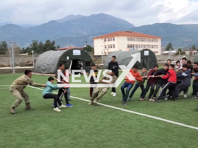 Soldiers play with children, earthquake victims, in Turkey, in undated footage. Thousands of people have been left homeless as a result of the earthquake and now live in tents. Note: Picture is a screenshot from a video. (@TCMilliSavunmaBakanligi/Newsflash)