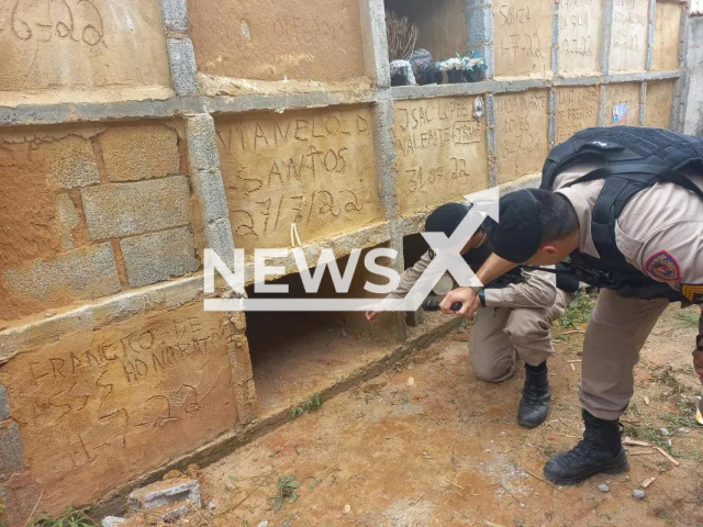 Picture shows the police officers by the tomb in Visconde do Rio Branco, Minas Gerais, Brazil, undated. A woman was rescued from a tomb. Note: Police photo. (Polícia Militar/Newsflash)