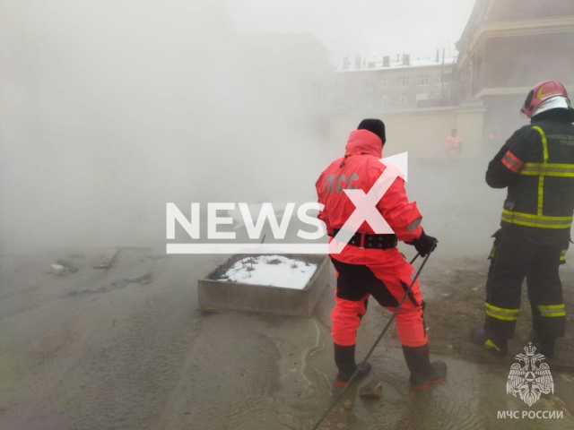 Emergency rescuers stand near a car into a pit with boiling water in the center of Saint Petersburg, Russia on Wednesday, Apr. 5, 2023. Four people were injured, including a child. Note: Picture is from the Russian Emergency Situations Ministry (@mchs_official/Newsflash)