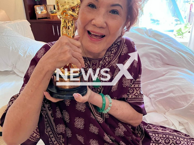 Michelle Yeoh's mother Datin Janet Yeoh  poses with  her daughters Oscar  in undated photo. 
The actress  brought her Best Actress Oscar statuette to her mum in Ipoh, Malaysia.
 Note: Private photo.  (@michelleyeoh_official/Newsflash)