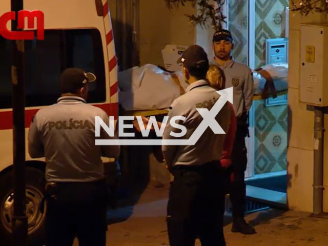 Picture shows police removing one of the bodies from  the  building where the bodies were found in Linda-a-Velha, Portugal, undated. A  woman died  and  police found   her fathers corpse she kept  for 15 years.
 Note: Photo is a screenshot from a video. (Newsflash)