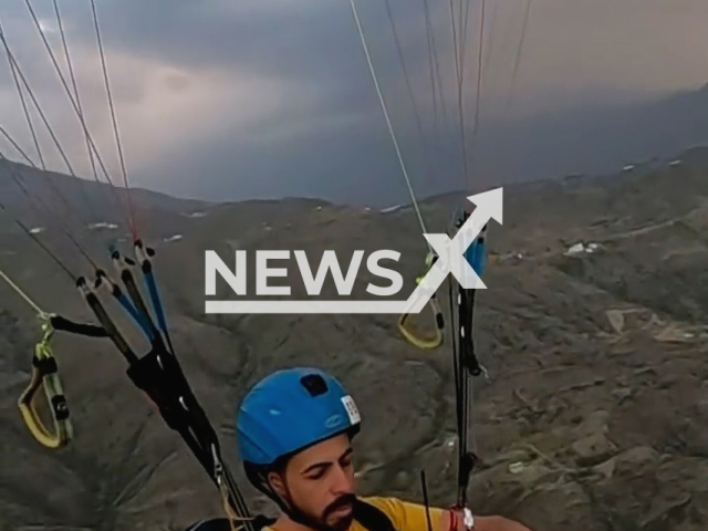 A Saudi man eats Iftar on a parachute over the mountains of Asir region, Saudi Arabia, undated. The man is called Abdulbari Al Abdullah and he is a tour guide.Note: Picture is screenshot from a video. (@Capt_Abdulbari/Newsflash)