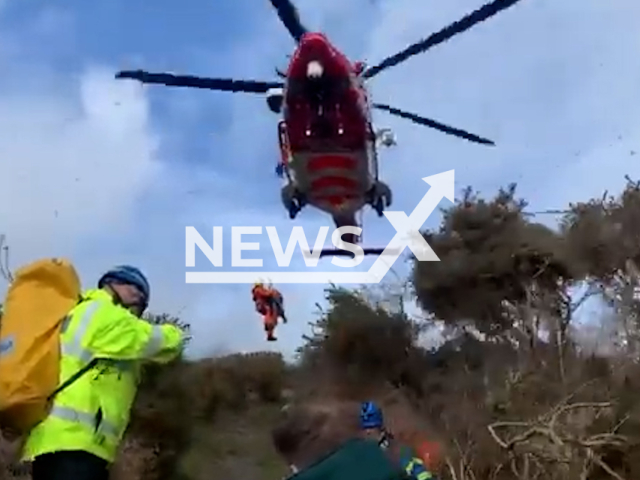 Coastguard Rescue Teams rescue Cari Ormerod, 47, near Marros Beach, in Carmarthenshire, on Saturday, March 25, 2023. Cari had fallen and broken her ankle during a walk. Note: Picture is screenshot from a video. (@MaritimeandCoastguardAgency/Newsflash)