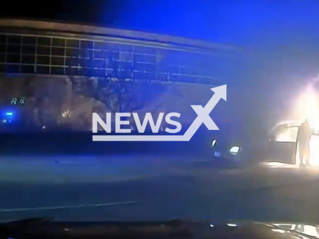 Officer helps driver to exit the vehicle that erupted in flames in Kenosha, Wisconsin, US, Tuesday, April 25, 2023. The tire was emitting sparks from the wheel. Note: Picture is a screenshot from a video (@Kenoshapolice/Newsflash)