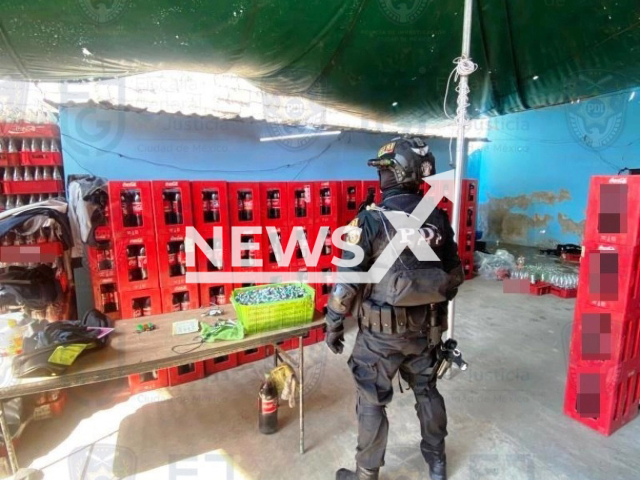 Police officer stands near bottles with fake Coca-Cola in the Santa Martha Acatitla Norte neighborhood, in Iztapalapa, Mexico, undated. Mexican authorities dismantled a clandestine factory of Coca-Cola and arrested two suspects. Note: Photo is obtained from the Mexico City Prosecutor's Office. (Mexico City Prosecutor's Office/Newsflash)