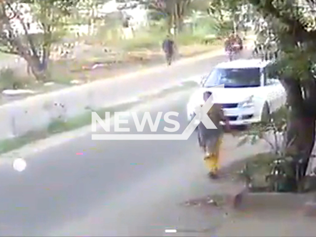 A man inside a car approaches a woman and snatches her chain in Peelamedu, Coimbatore, Tamil Nadu, India, undated. The woman was dragged on the road for a while before getting back up on her feet. Note: Picture is a screenshot from a video (Newsflash)