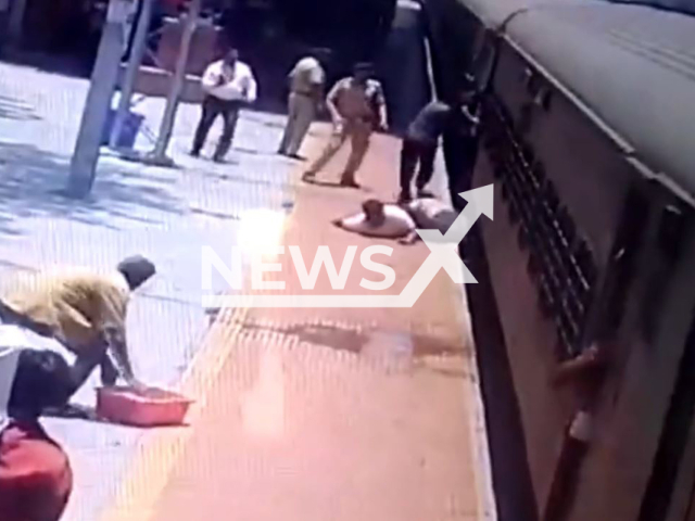 A boy slips into the gap between the platform and a moving train, after falling with his father, in Akola, India, on Tuesday, May 16, 2023. The boy was rescued unharmed in the incident.  Note: Picture is a screenshot from a video (@RPF_INDIA/Newsflash)