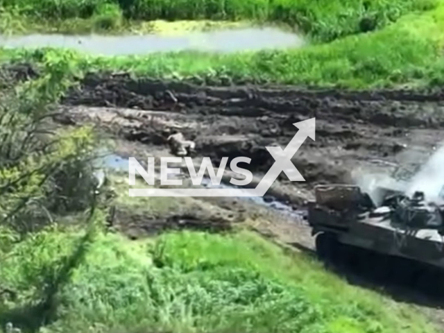 Russian soldier crawls away in mud from burning Russian Z tank with in Ukraine in undated footage. The footage was released by the 72nd Mechanized Brigade named after the Black Zaporozhians on Thursday, May, 18, 2023. Note: Picture is a screenshot from a video (@72.brigade.best/Newsflash)